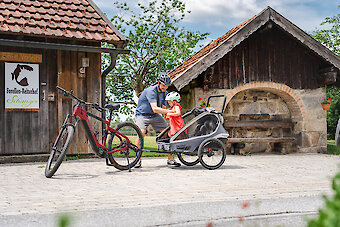 E-Bike mit Kinder-Anhänger beim Bauernhofurlaub